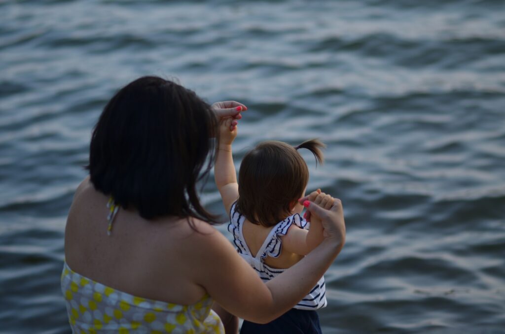 child and mom swimming in sea